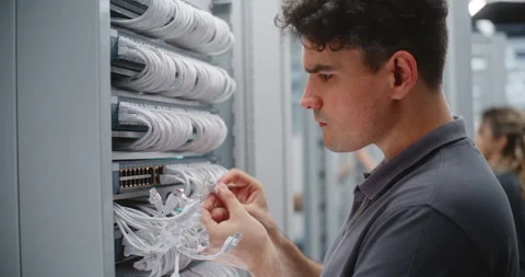Male IT Engineer Maintaining Patch Panel and Switch Connections in Data Center Stock Footage 344959029