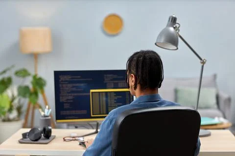 Male IT professional writing code while working at office workplace Stock Photos
