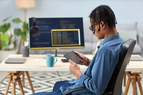 Male IT programmer holding tablet and writing code for mobile devices Stock Photos