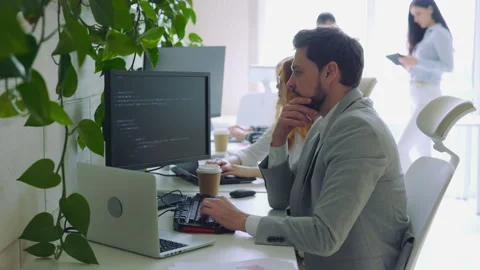 Male IT Programmer Thinking with Working on Computer. Guy Writing Code in Video stock 253260178