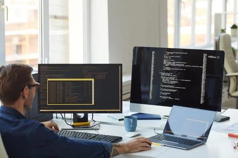 Male IT Programmer Using Computers with Code on Screen Stock Photos