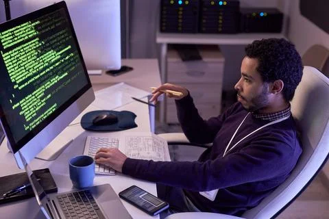 Male IT programmer writing code and using computer at office workplace Stock Photos