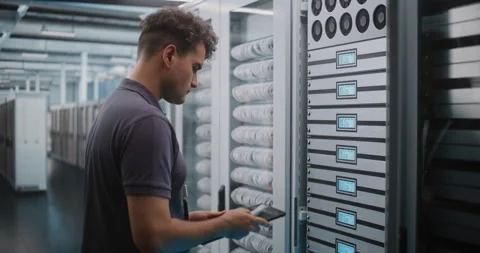 Male IT Specialist Unlocking Server Cabinet to Check Cooling Fans Video stock 344889334