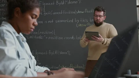 Male IT Teacher Explaining Coding Algorithm on Blackboard during Lesson Stock Footage 318716463