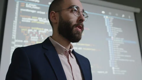 Male IT Teacher Typing Code on Tablet and Asking Question to Class Stock Footage 278125545