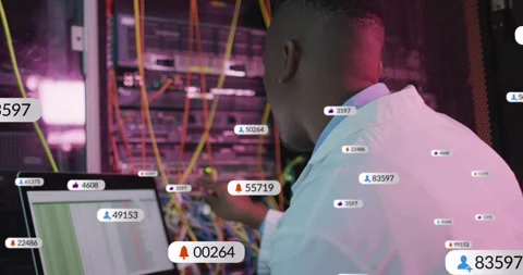 Male IT tech responding to appearing network badges, checking laptop and Stock Footage 333901087