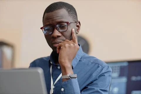 Male IT Worker Looking Down at Computer Screen 写真素材
