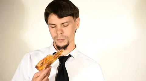 Male in jacket and tie eats pizza 動画素材 67982695