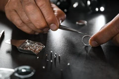 Male jeweler examining diamond ring in workshop, closeup view Stock Photos