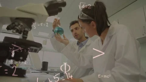 Male lab scientist lifting flask, analyzing blue sample while math overlaying 库存影片 322119152