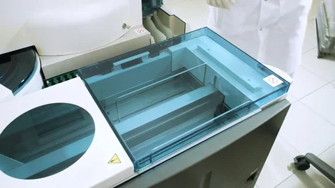 Male laboratory assistant analyzing samples of blood at modern equipment. HD Vídeo Stock 72390686