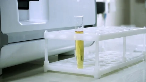 Male laboratory worker conducting a sample of urine at modern equipment. HD Stock Footage