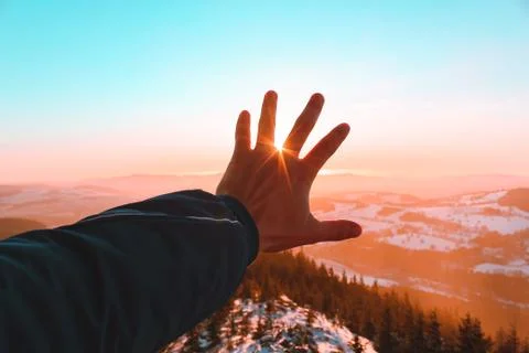Male left hand covering the sun in Czechia mountines Stock Photos