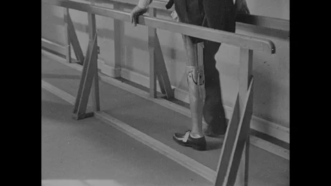 Male leg amputee training with his new artificial limb, doctor helping, 1944, UK Video stock 130663053
