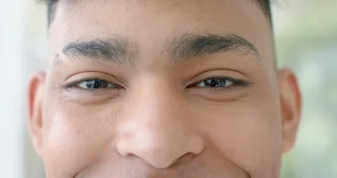 Male lifting eyebrows after locking gaze with camera, smiling and squinting near Stock Footage 337224649