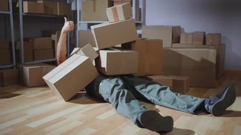 Male loader falling with boxes,shows thumbs up Video stock 288181742