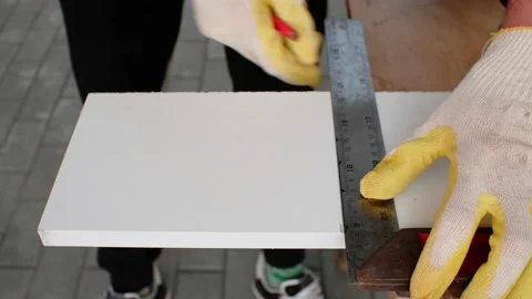 Male locksmith marks a segment on the workpiece with a square and a red pencil. Stock Footage 164156569