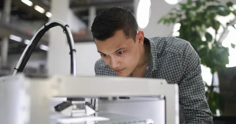 Male looking at 3D printer Stock Footage 86820341