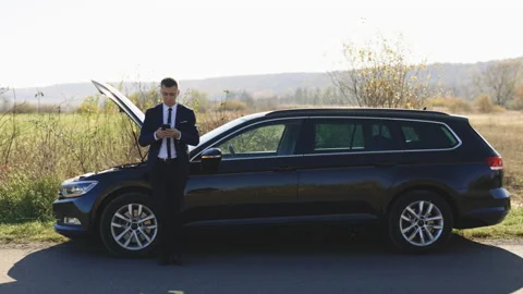Male man is using his smartphone because his car is broken. Portrait of upset Video stock 194754037