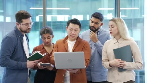 Male manager explains work issue to group of subordinate workers using laptop  Stock Footage 319070290