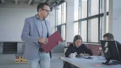 A male manager in a jacket walks around the office, communicates with colleagues Stock Footage 108871003