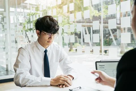 Male manager is talking or explaining about having to dismiss the employee .. Stock Photos