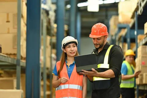 Male managers and worker checking newly arrived goods on digital tablet while Foto stock