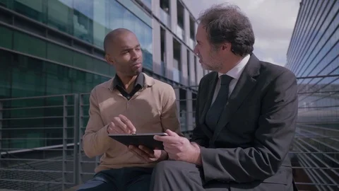 Male managers having discussion with tablet near office building Stock Footage 100138474