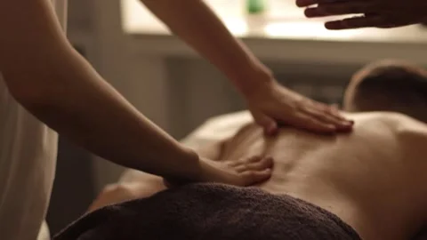 Male Massaged on Back by Two Massage Therapists in a Cozy Atmosphere Stock Footage 241324907