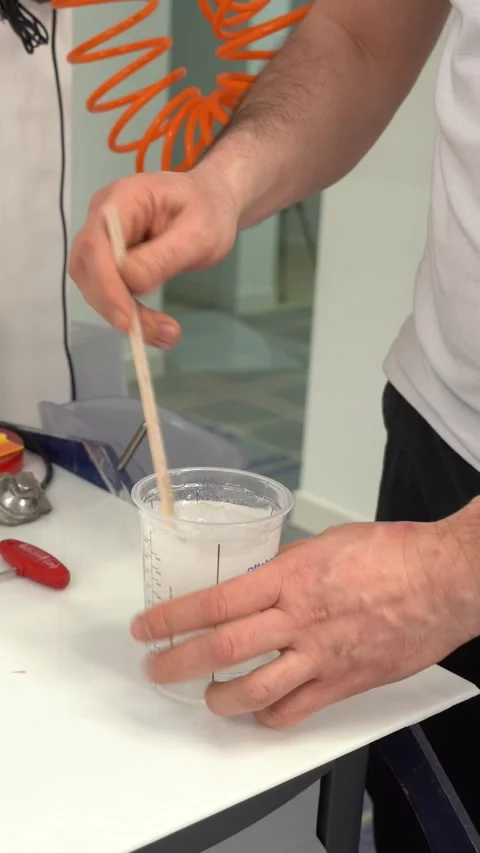 Male master mixing liquid solution while assembling prosthesis. Vertical video Stock Footage 237606024