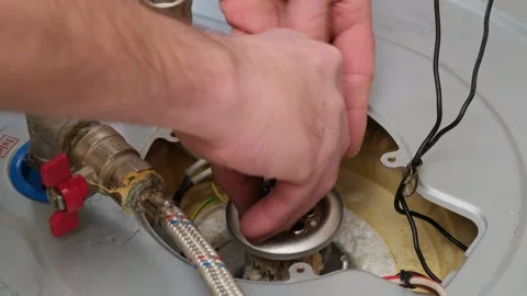 A male master takes a damaged heating element out of boiler Stock Footage 295424344