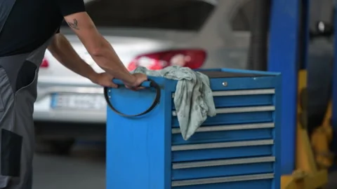 Male mechanic use different tools to repair broken automobile in garage Stock Footage 306807122