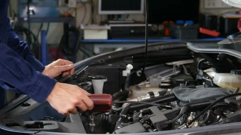 Male mechanic using Tachometer checking engine of a car Stock Footage 130126302