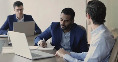 Male mentor teaching Indian intern, training new employee in office Stock Footage 252193779