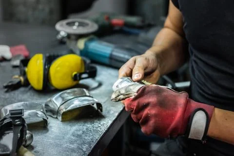 Male metal worker assembling piece of medieval armour suit Stock Photos
