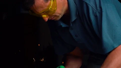 Male-middle-aged worker with angular grinding machine is cutting the metal Stock Footage