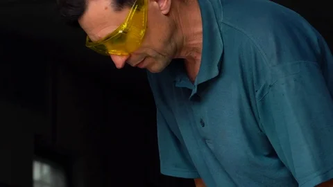 Male-middle-aged worker with angular grinding machine is cutting the metal Stock Footage 77909573