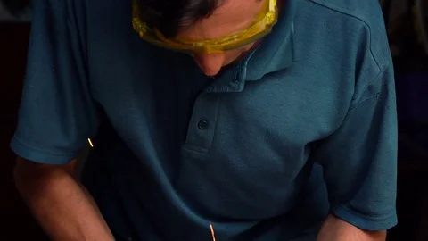 Male-middle-aged worker with angular grinding machine is cutting the metal Stock Footage 77909587