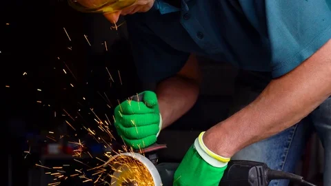 Male-middle-aged worker with angular grinding machine is cutting the metal Stock Footage 78424134