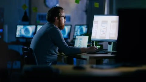 Male Mobile Application Developer Works with Graphics on His Personal Compute Stock Photos