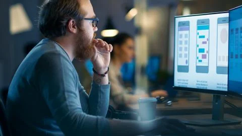 Male Mobile Application Developer Works with Graphics on His Personal Compute Stock Photos