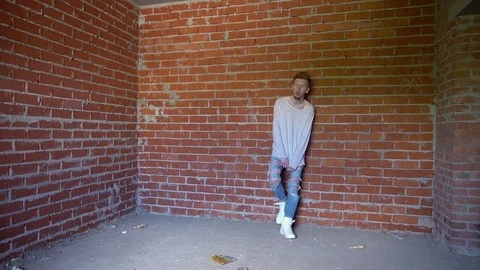Male model against a background of gray brick wall. Stock Footage 76448944