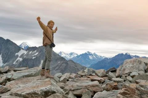 Male model posts at the top of snowcapped mountain peak around Aoraki Mount Cook Stock Photos