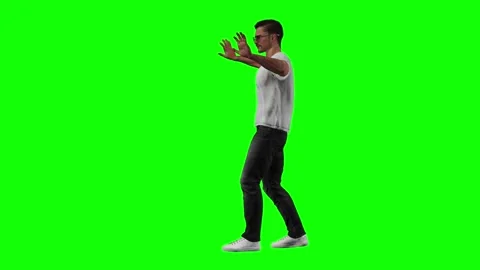 Male model walking and gesturing with expressive catwalk style on green Stock Footage 328639076