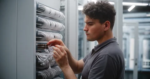 Male Network Engineer Patching Server Connections While Female Colleague Stock Footage 344967234