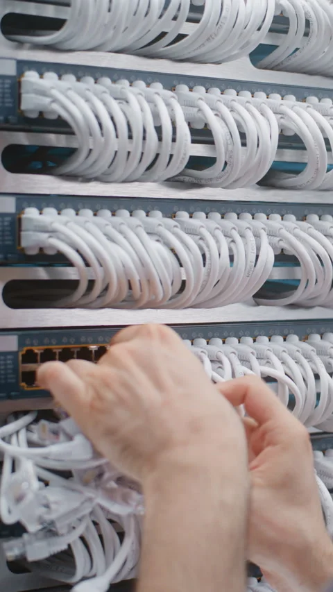 Male Network Technician Performing Physical Layer Cable Patching in Server Rack Stock Footage 344955238