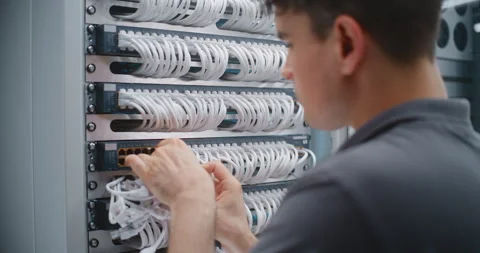 Male Network Technician Performing Physical Layer Cable Patching in Server Rack Stock Footage 344955295