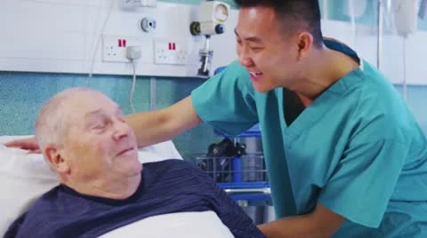 Male nurse at the bedside of an elderly male patient Stock Footage