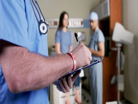 Male nurse's hands making notes while doctor talks to patient 4K Stock Footage 69384810