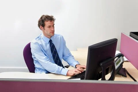 Male office worker sat working at his desk Stock Photos